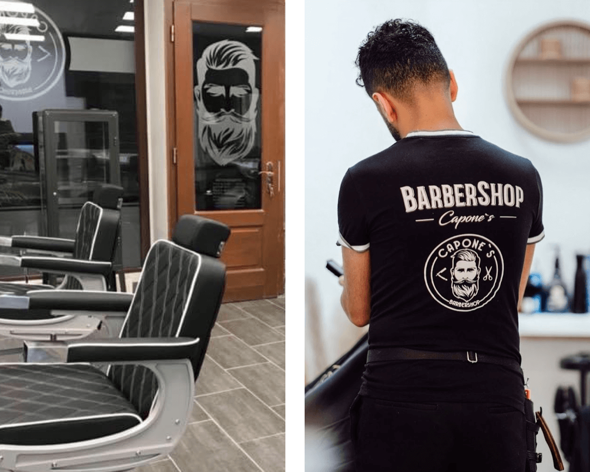 Links siehst Du die stilvoll eingerichteten Barbershop-Stühle vor einer Tür mit dem Logo von Capone’s Barbershop. Rechts steht ein Barber in einem schwarzen Shirt mit dem Barbershop-Logo und bereitet sich auf seinen nächsten Kunden vor.